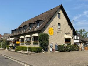 two people standing in front of a building at Hotel Bienefeld in Korschenbroich