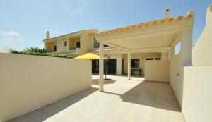 een patio van een huis met een wit hek bij Holiday House in Albufeira