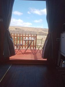 a view of a table and a bench from a window at Wee Hoose Glaping Pod 2 in Skail