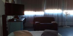 um quarto com uma cama, uma cadeira e uma televisão em Résidence Mayol em Toulon