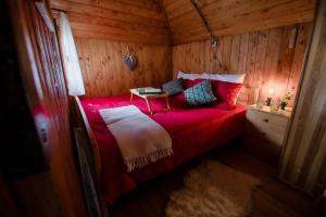 a bedroom with a red bed in a wooden room at Chalet Pinja - I FEEL ALPS in Stahovica