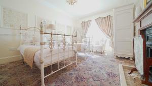 a white bedroom with a bed and a window at The Old Tramhouse Self Catering Traditional Charming Apartments Located In The Heart Of Historic Stirling For Short-Long Stays In Stirling For Tourism & Events & Contractor Base Stays For Central Belt Area & Open To Book All Year Round in Stirling