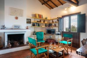 sala de estar con mesa, sillas y chimenea en Sardegna Homes Casa Rosa, en Badesi
