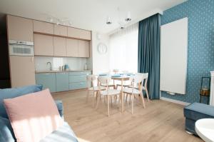 a kitchen and dining room with a table and chairs at Komfortowy Apartament PASTELOWY - 2 sypialnie in Kołobrzeg