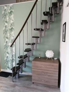 a staircase with black railings and a wooden dresser at Le regard de Mona Lisa in Amboise