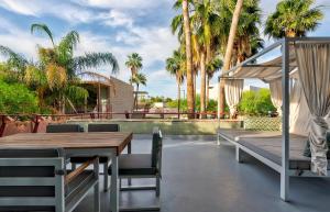 un patio con mesa, sillas y palmeras en Hotel Valley Ho, en Scottsdale
