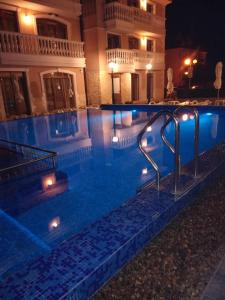 una piscina frente a un edificio por la noche en Guest House Aristokrat en Obzor