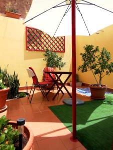 Un patio con una sombrilla y una mesa y sillas. en Casa Rural Jardín del Desierto, en Tabernas