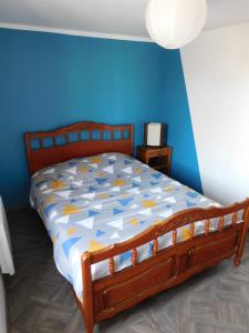 - une chambre avec un lit en bois et un mur bleu dans l'établissement Chez Simone, au Tréport