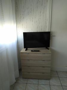 a flat screen tv sitting on top of a dresser at Petite halte Appt 103 in Sens