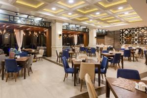 a restaurant with wooden tables and blue chairs at Jermuk Hotel and SPA in Jermuk