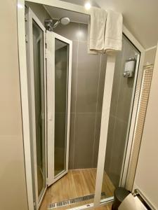La salle de bains est pourvue d'une douche avec une porte en verre. dans l'établissement Oplonti s House Apartment Boscomonaco, à Torre Annunziata
