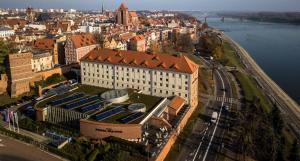 an aerial view of a building with solar panels on it at Hotel Bulwar in Toruń