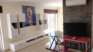 a living room with a glass table and a television at Vista Mar em todo apartamento in Portimão