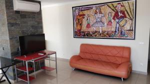 Vista Mar em todo apartamento في بورتيماو: غرفة معيشة مع أريكة وتلفزيون