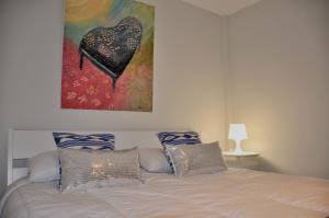 Villa Alegria في سانتا بريخيذا: غرفة نوم بسرير مع لوحة على الحائط