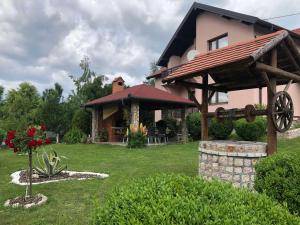 a house with a gazebo in a yard at Apartments Dedic in Dubrave Gornje