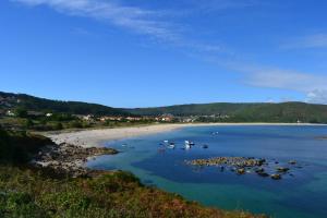 a view of a beach with boats in the water at Fisterracons in Finisterre