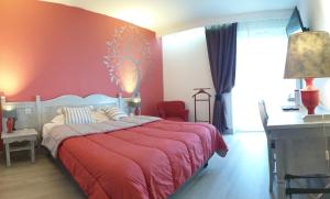 a bedroom with a bed, a desk, and a lamp at Les Jardins du Forez in Montrond-les-Bains