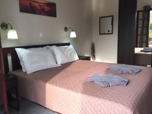 a bedroom with a bed with two towels on it at Alexander Apartments in Roda