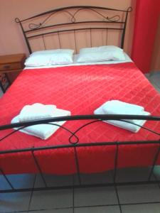 a red bed with two white towels on it at Ktima Edem in Kamares