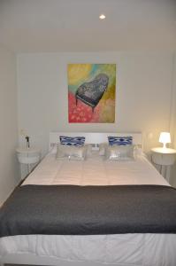 Villa Alegria في سانتا بريخيذا: غرفة نوم بسرير كبير عليها لوحة على الحائط