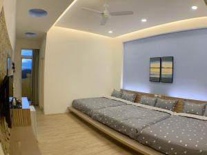 a bedroom with a large bed and a ceiling at Moumoon B&B in Magong