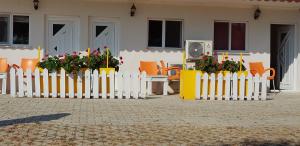 a white picket fence with flowers and a table and chairs at Ciftlik Hotel in Cesme