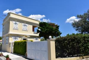 a white fence in front of a white house at Jasmine Home, Aegina City in Egina