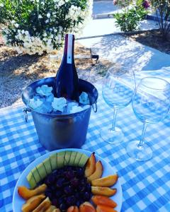 a bottle of wine and a plate of fruit on a table at Ciftlik Hotel in Çeşme