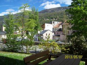 a bench sitting in a park with a view of a town at Hébergement Coup de Coeur in Ax-les-Thermes