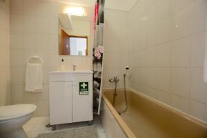 a bathroom with a sink and a toilet and a tub at Edificio Caique C in Armação de Pêra