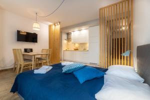a bedroom with a blue bed and a dining room at BierzCzadowy Apartament in Ustrzyki Dolne