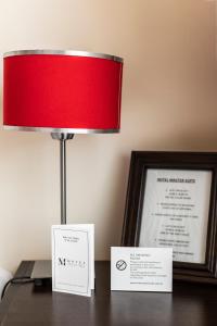 una lámpara roja sentada en un escritorio junto a una foto en Hotel Boutique Devoto en Buenos Aires