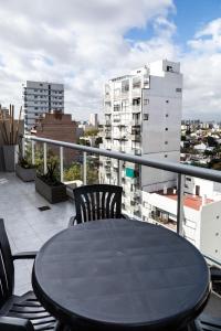 un tavolo e sedie su un balcone con vista sulla città di Hotel Boutique Devoto a Buenos Aires