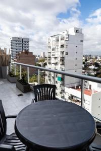 a table and chairs on a balcony with a view of a city at Hotel Boutique Devoto in Buenos Aires
