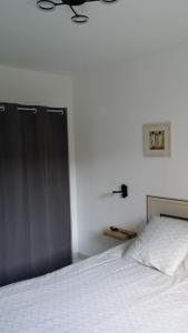 尚皮涅的住宿－Le 10 Bis，卧室配有一张白色的床和黑色的门