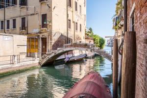 eine Brücke über einen Kanal mit Booten im Wasser in der Unterkunft Vivaldi in Venedig