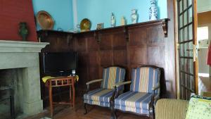 een woonkamer met 2 stoelen en een televisie bij Casal dos Zimbros in Cortiços
