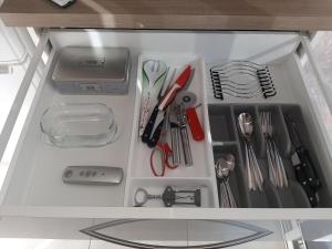 uma gaveta cheia de utensílios de cozinha num armário em Vacances cocooning em La Londe-les-Maures