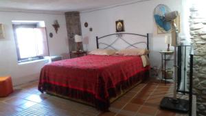 a bedroom with a bed with a red blanket and a window at Vivere un sogno...living a dream... in Rocca Imperiale