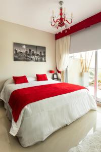 a bedroom with a red and white bed with a chandelier at Hotel Boutique Devoto in Buenos Aires