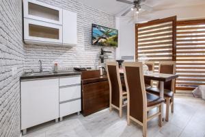 弗瓦迪斯瓦沃沃的住宿－Apartament Dorotka，厨房配有白色橱柜和桌椅