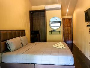 a bedroom with a bed with two towels on it at Binlha Raft Resort in Sai Yok