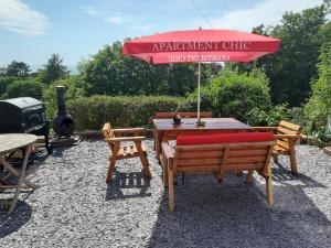a table and chairs with an umbrella and a grill at Apartment Chic in Barmouth