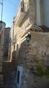 a stone building with a street light and a balcony at Vivere un sogno...living a dream... in Rocca Imperiale