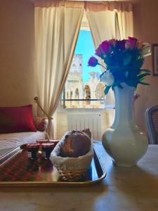 a table with a tray of bread and a vase with flowers at Appartement aux Arènes in Arles