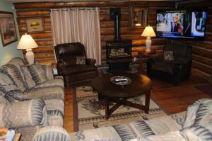 ein Wohnzimmer mit Sofas und einem Holzofen in der Unterkunft Yellowstone Motel - Adults Only - All rooms have kitchens in West Yellowstone