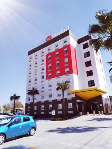 une voiture bleue garée devant un hôtel dans l'établissement Hotel Hi ! Torreon Aeropuerto-Galerías, à Torreón