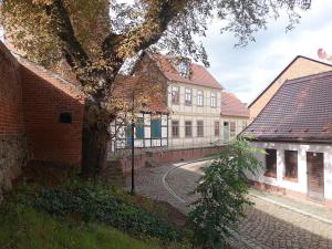 een groep gebouwen met een boom en een straat bij Schrot-Kontor in Tangermünde